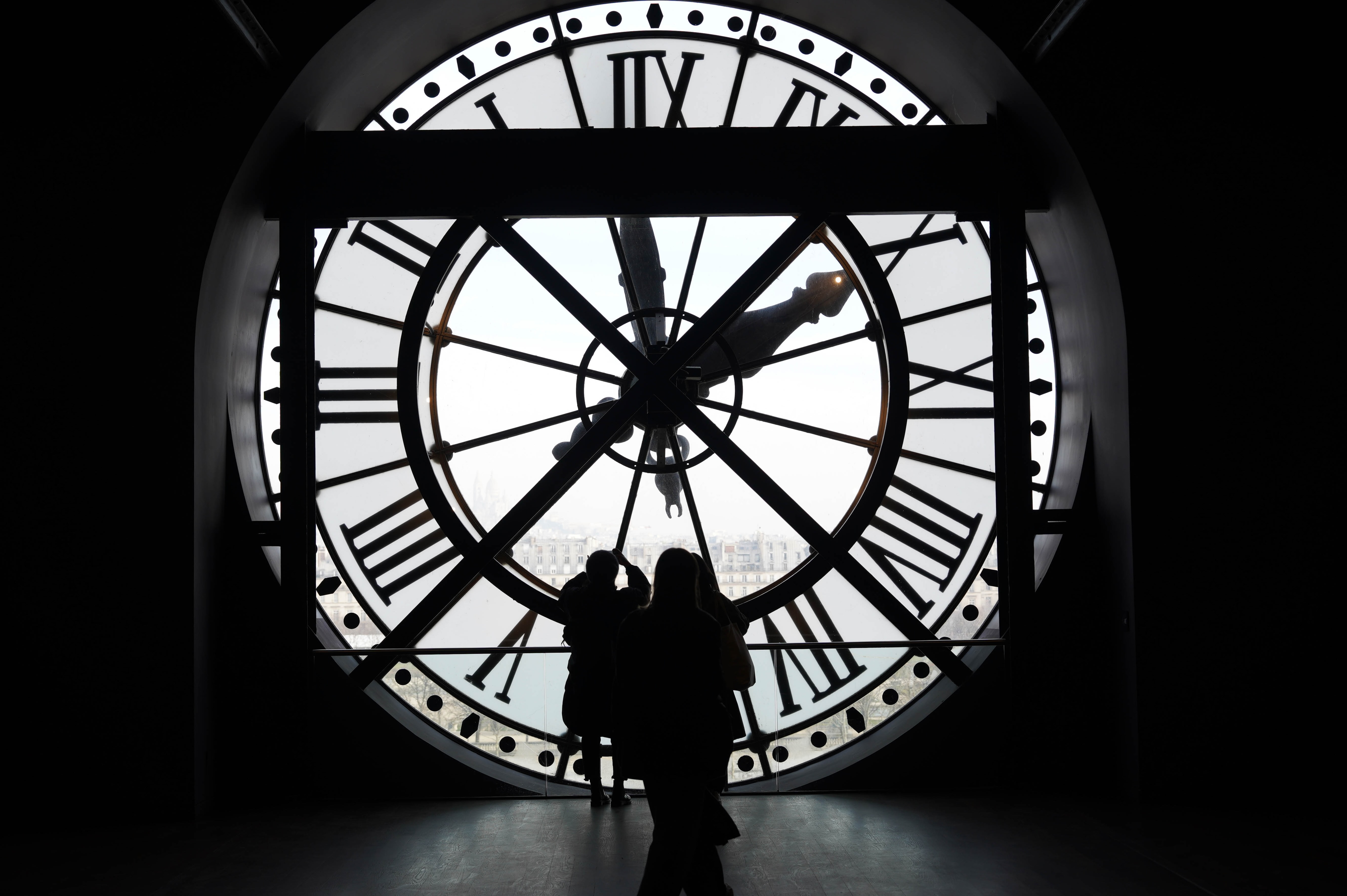 유럽 랜드마크 대형 시계 너머로 보이는 도시 전경과 여행자 실루엣